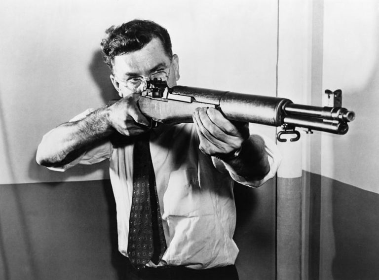 John Garand aiming the M1 rifle he designed